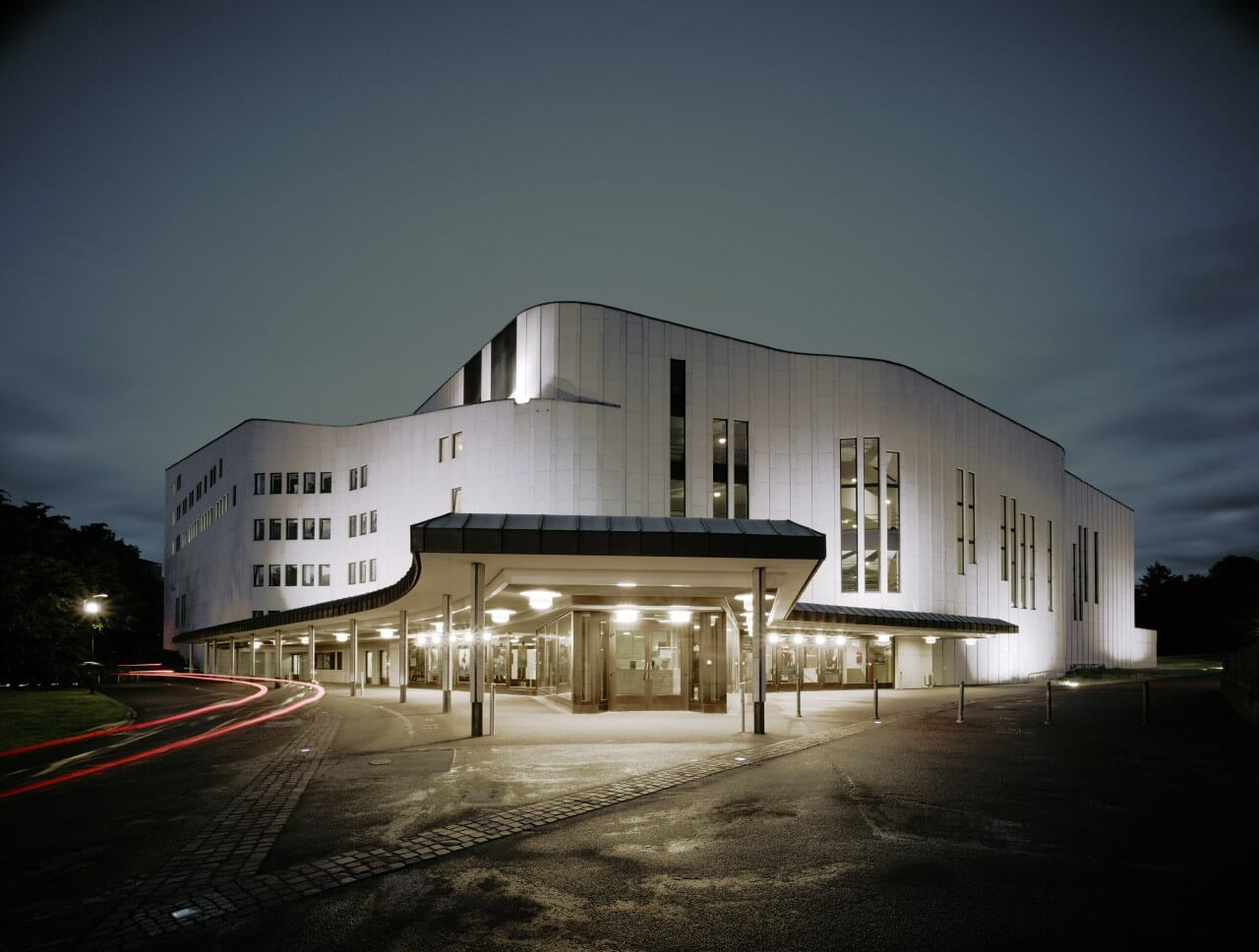 Man sieht das Aalto-Musiktheaters Essen. Im Vordergrund der Haupteingang des Gebäudes.