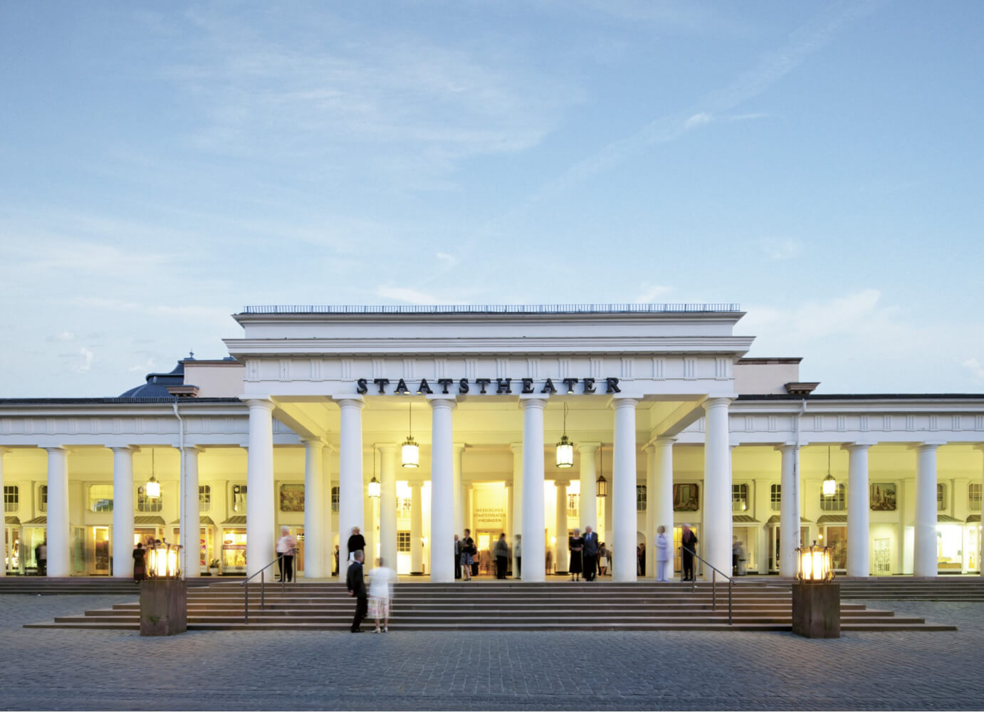 Man sieht den Haupteingang des Großen Hauses und Kolonnaden des Hessischen Staatstheaters Wiesbaden.