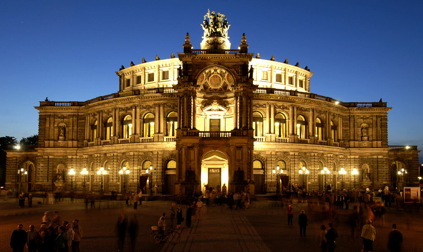 Zu sehen ist die Semperoper Dresden auf dem Theaterplatz in der Dämmerung