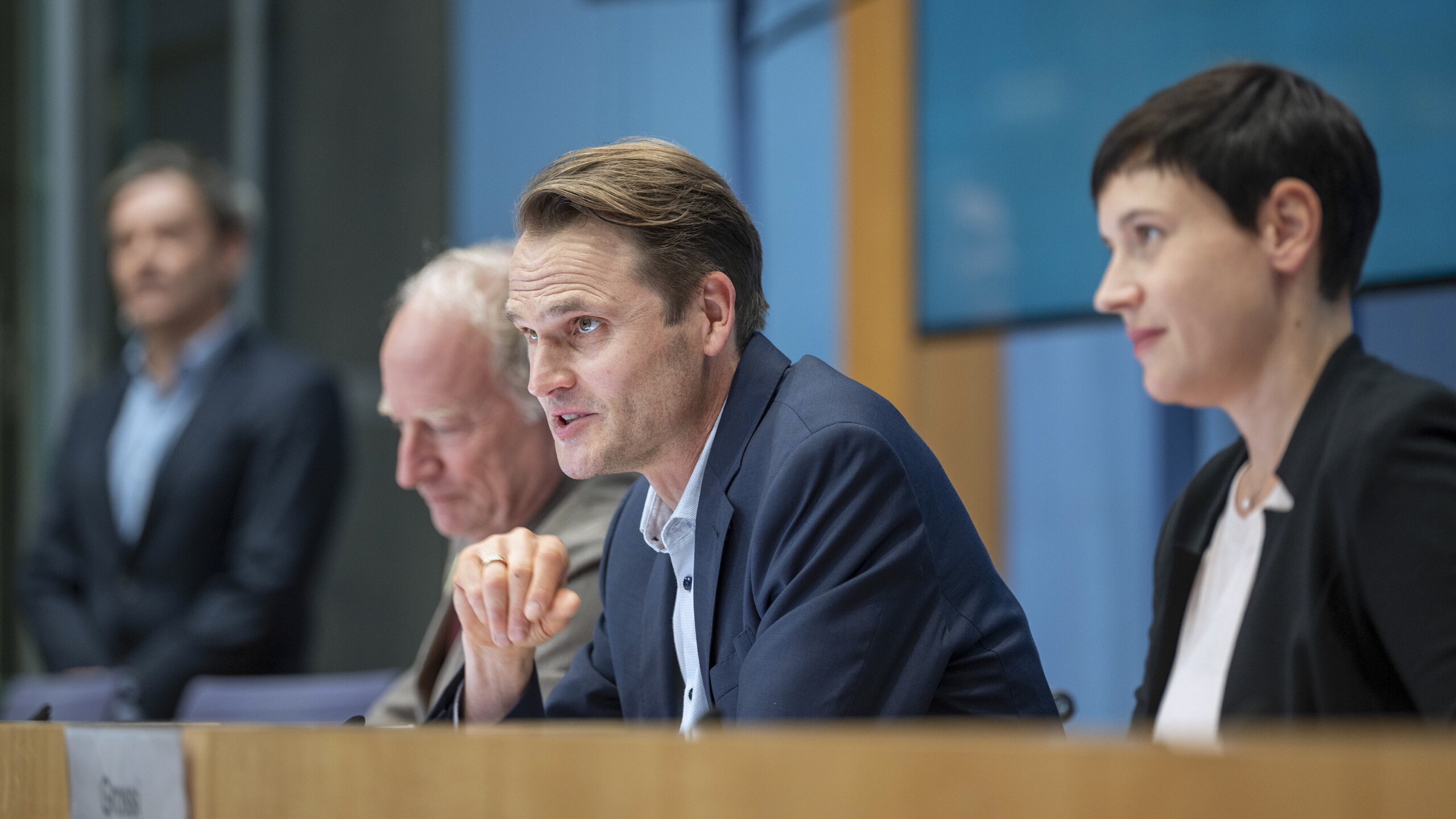 Fabian Hinrichs, Stefan Merki und Klara Pfeiffer sitzen am Podium der Pressekonferenz und stellen sich den Fragen der Journalist:innen.